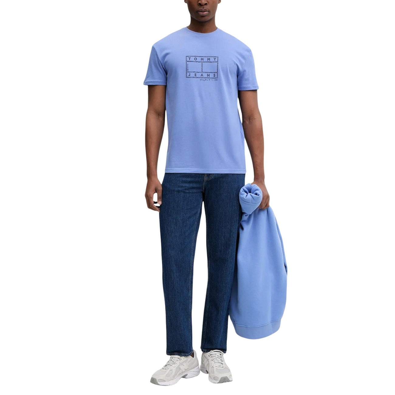 T-shirt Tommy Jeans Azzurra; 100% Cotone Rigenerato. Regular fit, stampa grafica frontale, girocollo a costine. Stile casual sostenibile, ideale per la stagione calda e il tempo libero. Figura intera 