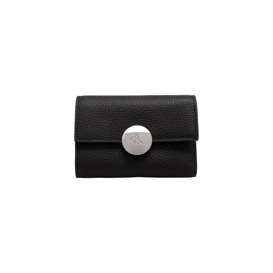 Portafoglio Compatto Donna Calvin Klein Trifold; Nero. 100% Vera pelle martellata, chiusura con automatico logato, scomparti interni per carte, banconote e portamonete zippato. Dimensioni micro (6x9 cm), stile elegante 4 stagioni. Vista frontale 