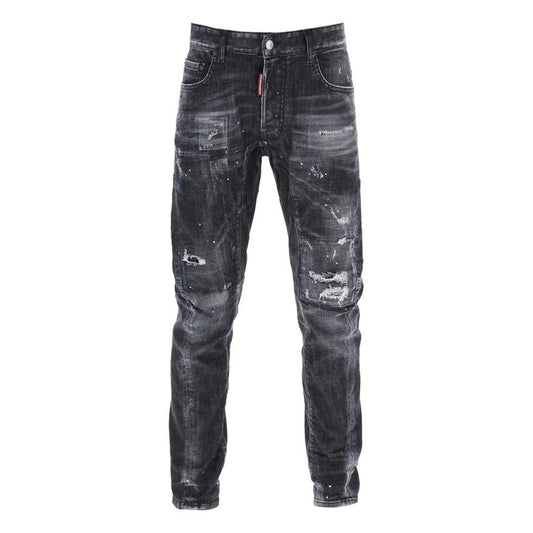 Jeans Dsquared2 Skater Fit; Black Wash Distressed. Dettagli con vernice, rammendi e patch rossa iconica. Taglio affusolato, denim di alta gamma, stile urban-premium. Vista frontale 