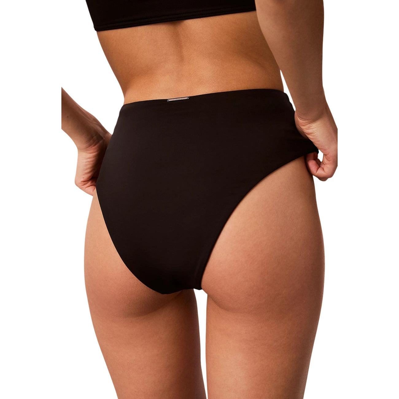 Slip Bikini Vita Alta Calvin Klein; Nero. Tessuto tecnico anti-umidità, asciugatura rapida. Interamente foderato, cuciture invisibili, placca logo posteriore. Stile modellante e sofisticato. Vista posteriore 
