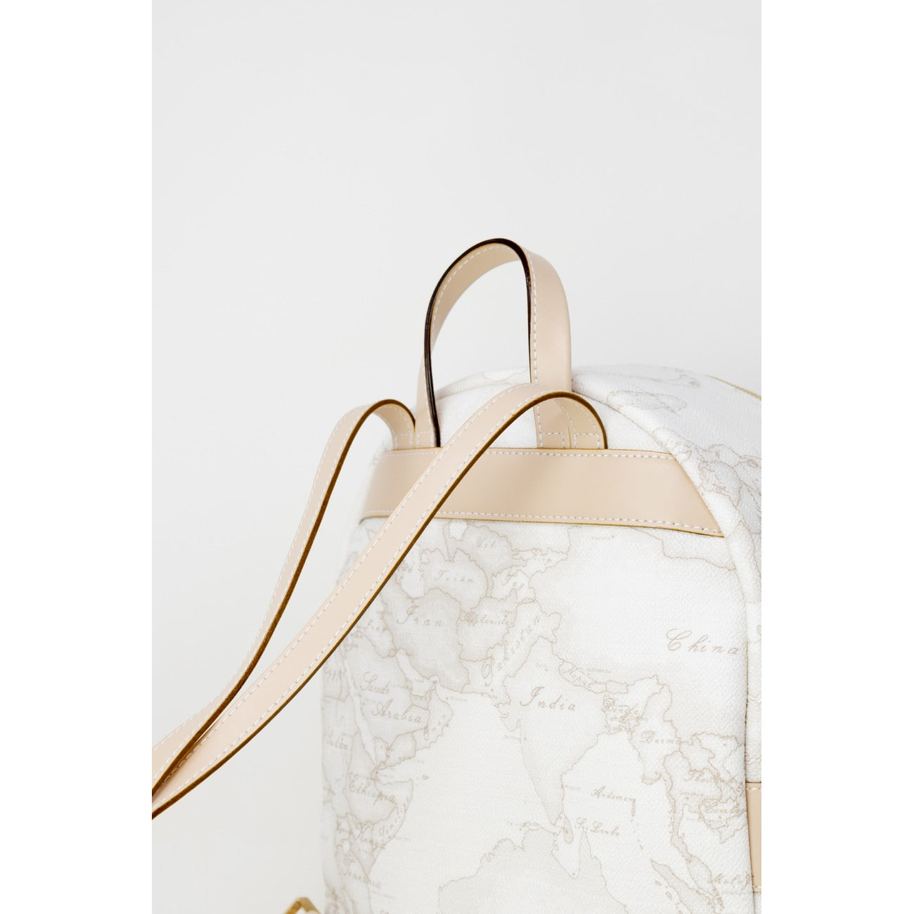 Zaino Medio Donna Alviero Martini Prima Classe; Bianco Geo White. 40% Pregiata pelle stampata con dettagli in metallo oro lucido. Chiusura con zip, tasca frontale e spallacci regolabili. Misure slanciate e capienti (25x29 cm), stile Heritage contemporaneo. Dettaglio 