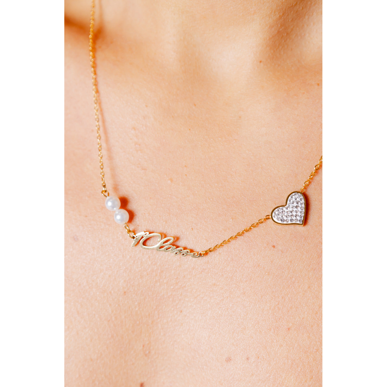Collana Alviero Martini Prima Classe; Acciaio Dorato. Pendenti cuore con cristalli, perle e scritta Love. Dimensioni 30x1 cm, bicolore, anallergica e resistente. Accessorio chic per ogni occasione. Vista indossata 