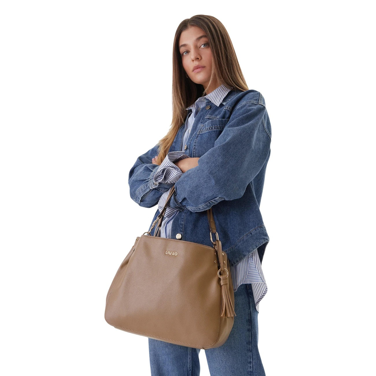 Borsa Liu Jo ECS M Satchel color Cammello; 100% Poliuretano. Charm con frangia, dettagli dorati, doppi manici. Borsa media versatile, elegante e capiente. Indossata da modella 