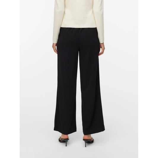 Pantaloni Donna Fantasia Nero Vero Moda Loose Fit; Taglio morbido e fluido in poliestere elasticizzato. Struttura senza chiusura con dettaglio bottone e tasche anteriori, stile casual primavera-estate. Vista Posteriore 