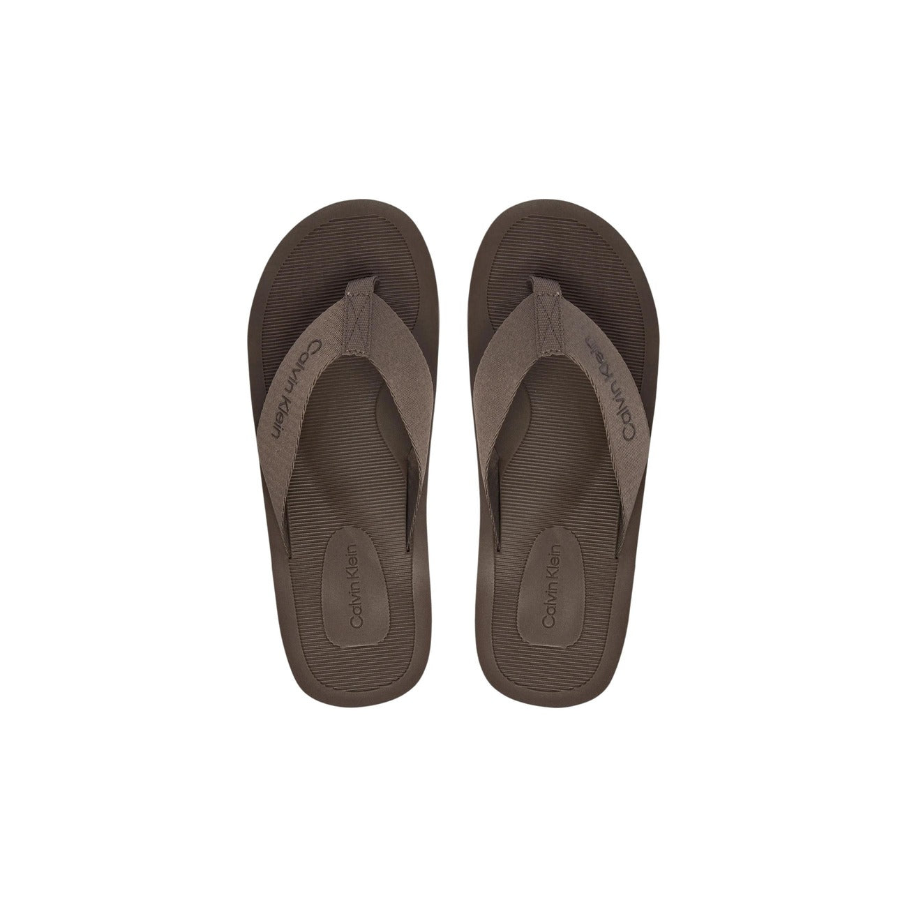 Infradito Calvin Klein HM0HM02106; 100% Poliestere. Doppia stampa logo, suola grip, fascia ampia. Ciabatte uomo mare e piscina, leggere e resistenti per la PE26. Colore marrone vista frontale 