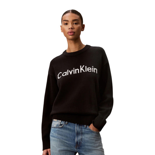 Maglione Girocollo Donna Nero Calvin Klein Jeans; Maglia in puro cotone con maxi logo frontale a contrasto. Silhouette regolare con spalle scese, polsini a costine e stile casual. Frontale 