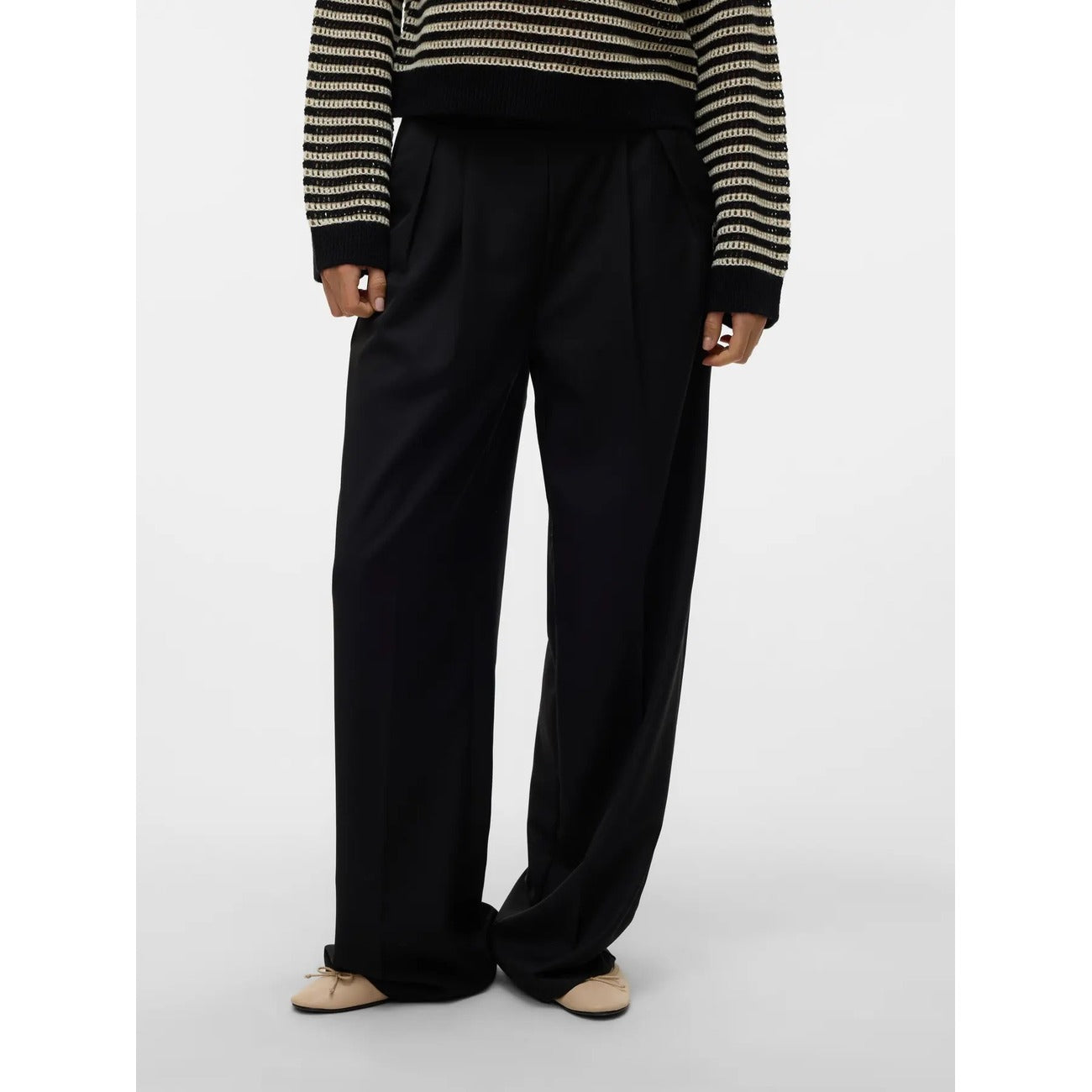 Pantaloni Donna Neri Vero Moda Wide Leg; Taglio a gamba larga in poliestere e viscosa fluida. Vita alta con pieghe frontali, chiusura con zip e tasche anteriori, stile casual-elegante continuativo. Vista frontale 