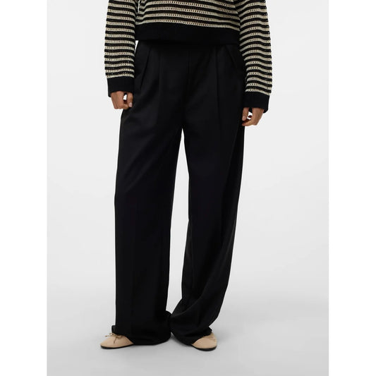 Pantaloni Donna Neri Vero Moda Wide Leg; Taglio a gamba larga in poliestere e viscosa fluida. Vita alta con pieghe frontali, chiusura con zip e tasche anteriori, stile casual-elegante continuativo. Vista frontale 