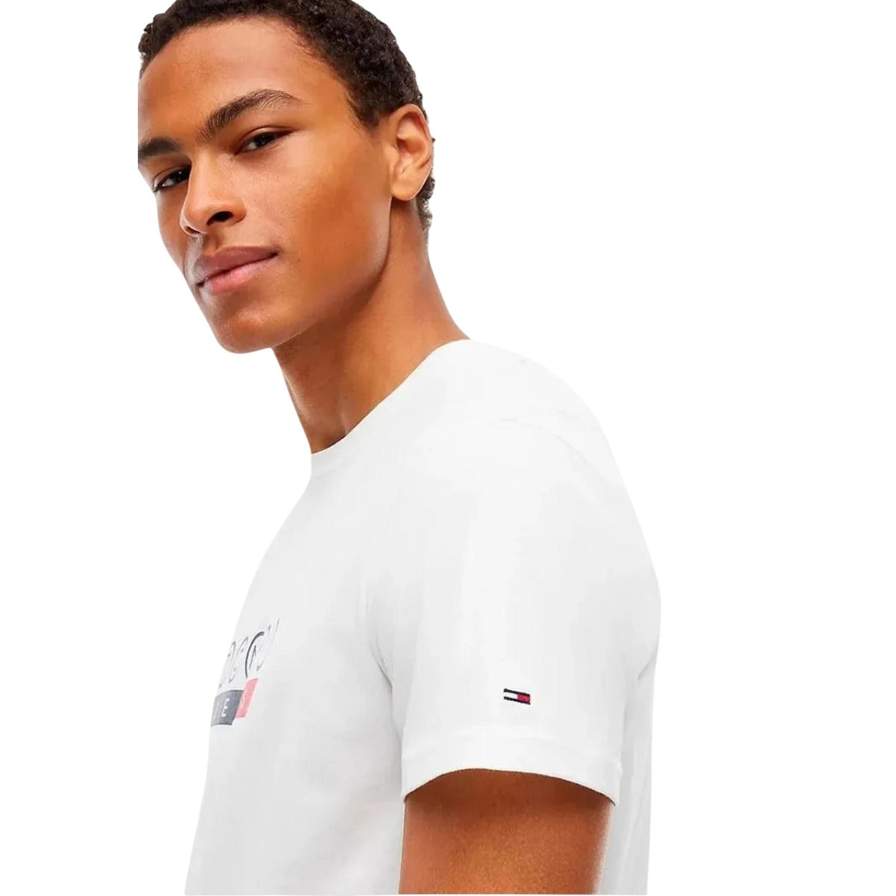 T-shirt Tommy Jeans bianca uomo DM0DM23715. Maglietta da uomo bianca a maniche corte in cotone rigenerato ecosostenibile con girocollo e stampa grafica logo Tommy Hilfiger sul petto, t-shirt casual e streetwear.