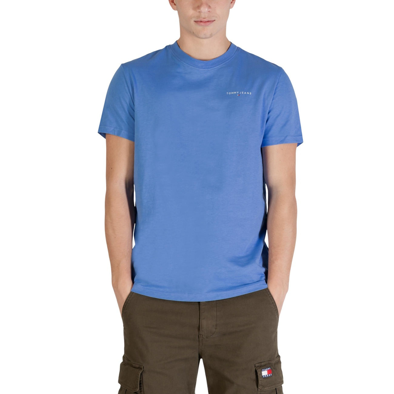T-shirt Tommy Jeans Slim Linear; 100% Cotone Rigenerato. Taglio slim fit, logo frontale distintivo, maniche corte. Comfort sostenibile per un look casual ricercato. Colore azzurro. Vista frontale 
