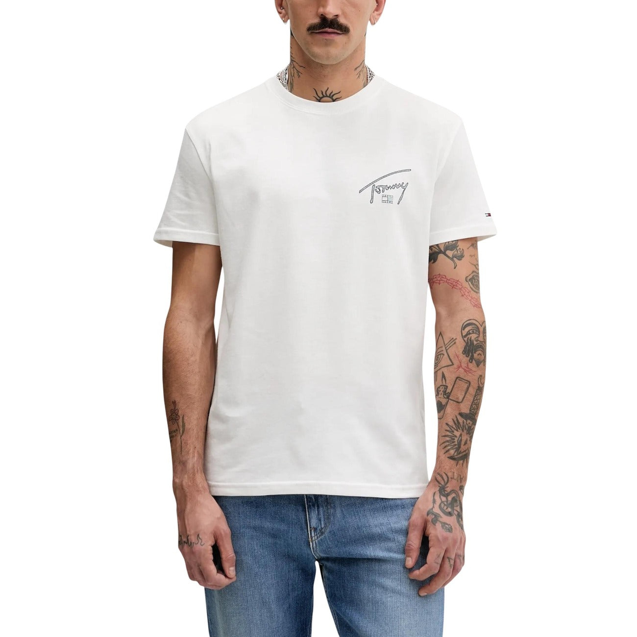 T-shirt Tommy Jeans Graffiti; 100% Cotone. Logo firma oversize sul retro, branding sul petto, vestibilità regular. T-shirt uomo fresca e traspirante dal design urban-art. Colore bianco vista frontale