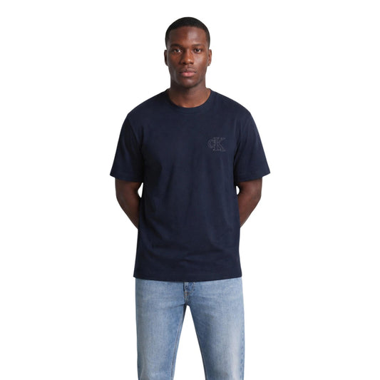 T-shirt Blu navy Calvin Klein; Logo Goffrato in rilievo. 100% Jersey di Cotone. Vestibilità regolare, girocollo a costine, morbidezza premium. Stile minimalista e ricercato. Vista frontale 