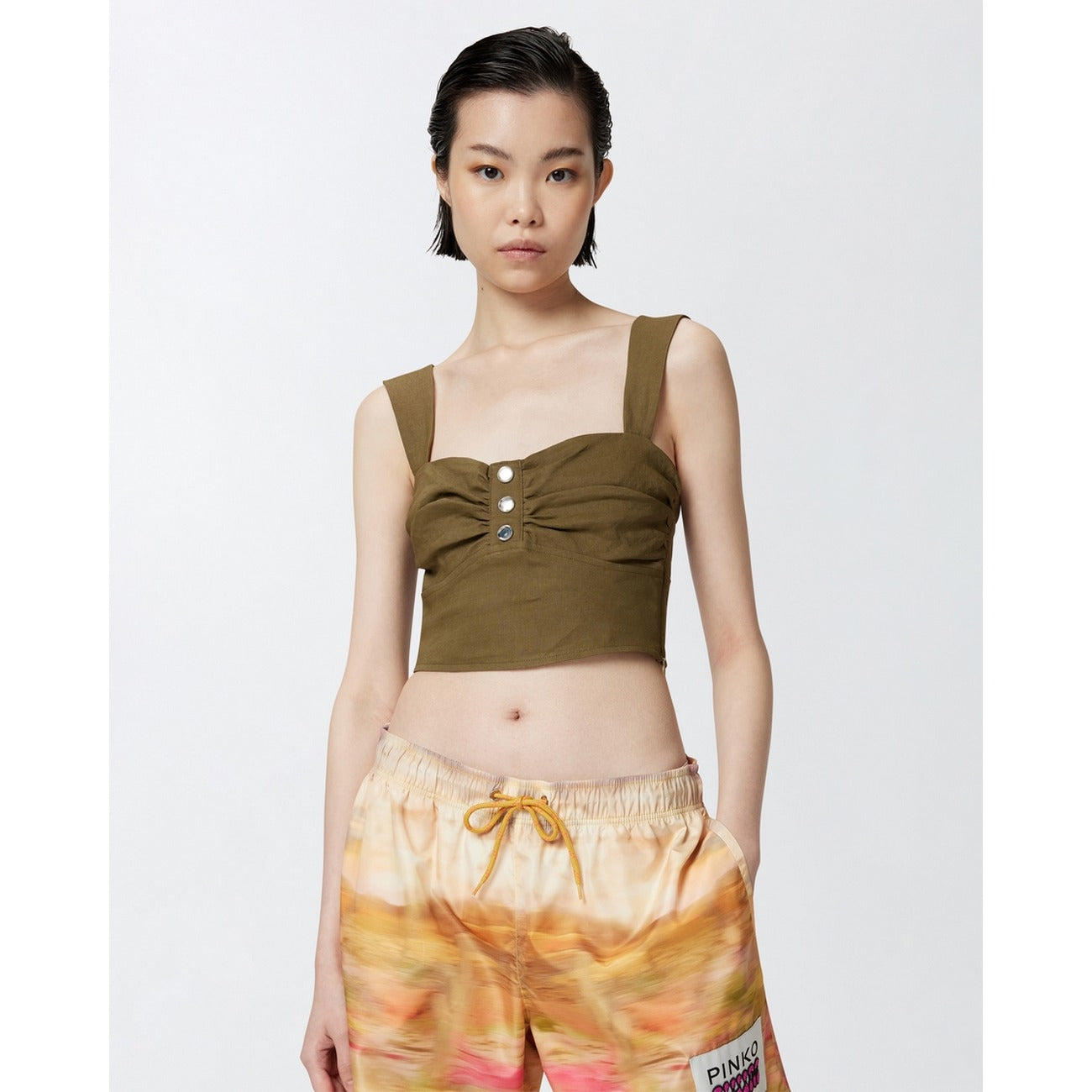 Top Pinko Verde; 55% Lino, 42% Viscosa. Schiena scoperta, chiusura con zip, bottoni decorativi. Tessuto leggero, vestibilità elegante, ideale per eventi estivi e tempo libero chic. Vista frontale 