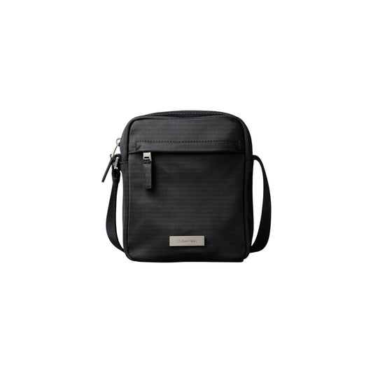 Borsa Tracolla Uomo Calvin Klein Clean Reporter; Nero. 100% Nylon riciclato ecosostenibile, doppia chiusura con zip, tracolla regolabile in tessuto e divisori interni. Dimensioni compatte (16x20 cm), stile minimalista e leggero. Vista frontale 