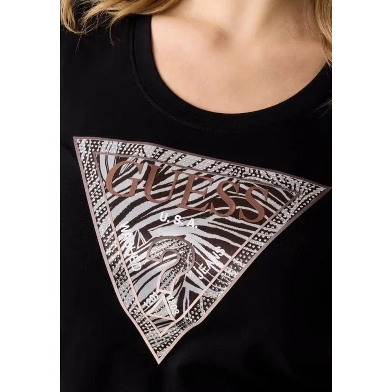 T-shirt Guess Nera Logo Zebra; 95% Cotone, 5% Elastam. Modello slim fit, maniche corte, scollo tondo. Logo a triangolo con stampa zebrata, tessuto leggero e flessibile. Dettaglio logo 