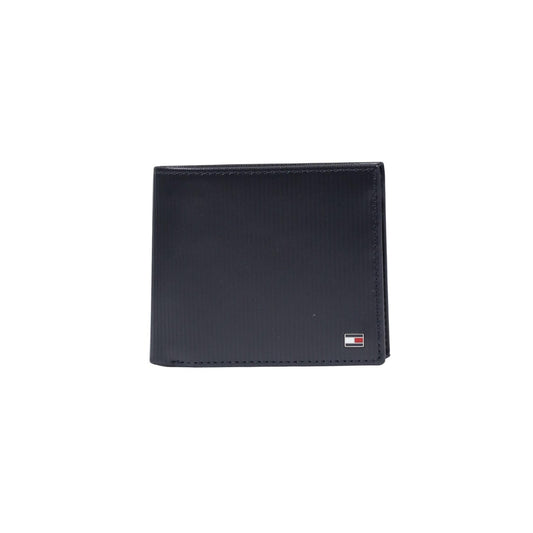 Portafoglio uomo Tommy Hilfiger; 100% Pelle Blu Navy. Portamonete a bottone, texture rigata, logo in metallo. Formato standard capiente, stile classico 4 stagioni. Vista frontale 