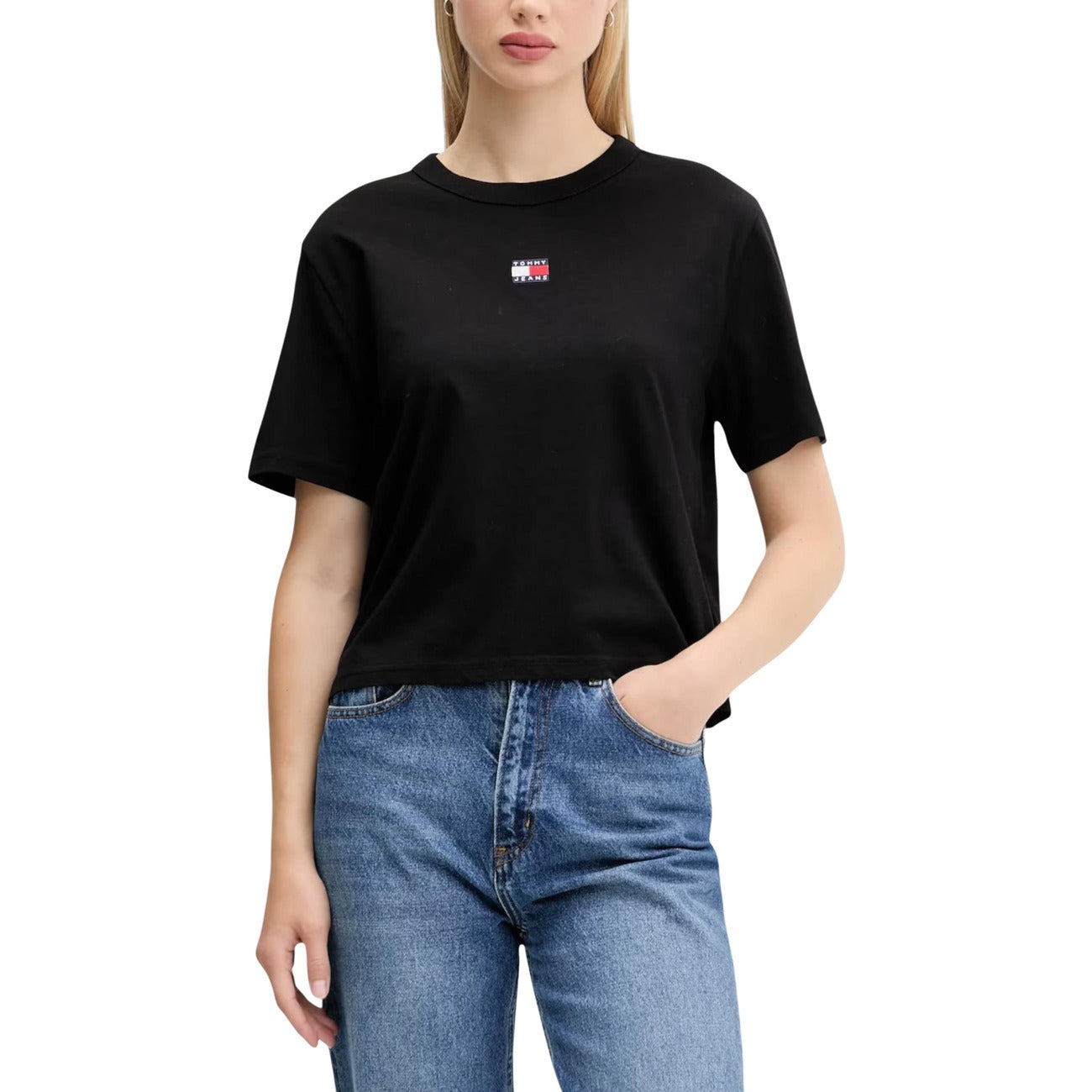 T-shirt Donna Tommy Jeans Boxy Cropped; 100% Cotone. Spalle scese, logo badge sul petto, taglio corto. Maglia donna fresca e di tendenza per la PE26. Colore nero 