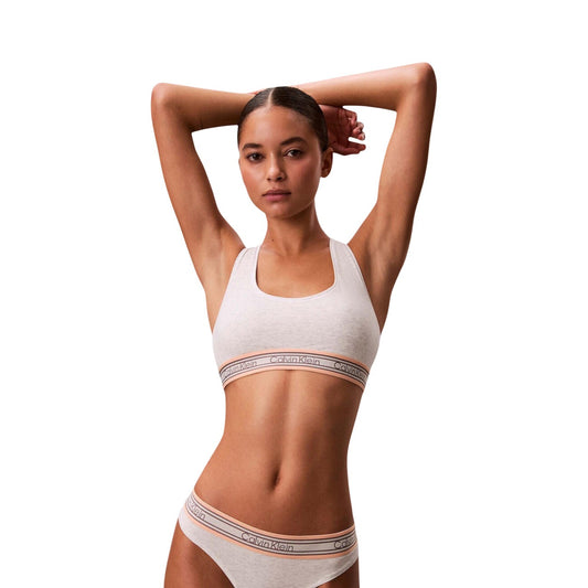 Bralette Sfoderata Bianco Donna Calvin Klein; Tessuto elasticizzato in cotone e modal con retro a vogatore e coppe senza imbottitura. Modello pull-on con fascia piatta senza cuciture, stile sportivo primavera-estate. Vista Frontale 