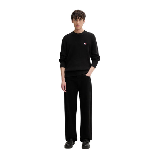 Maglione Tommy Jeans uomo nero DM0DM20923. Pullover a girocollo in cotone sostenibile con lavorazione a maglia spessa, maniche lunghe, bordi a costine e logo classico applicato sul petto.