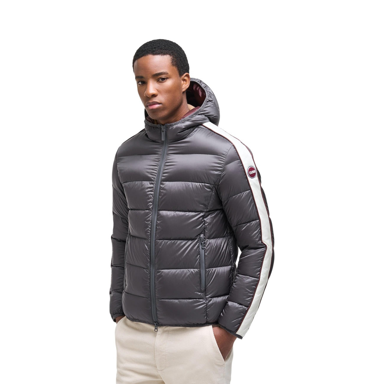 Piumino Colmar uomo grigio Heritage. Giaccone invernale bicolore idrorepellente con cappuccio, imbottitura in piuma d'oca naturale certificata RDS, tessuto riciclato e patch logo Colmar in feltro.