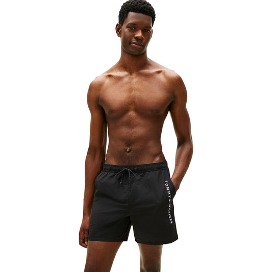 Costume Shorts Tommy Hilfiger; Nero. 100% Nylon. Lunghezza media (40,5 cm), chiusura con lacci, tasca laterale con zip. Dettagli iconici e logo ricamato, lavabile a 30°C. Vista frontale 