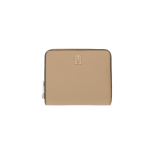 Portafoglio Compatto Donna Tommy Hilfiger; Beige. Finitura zigrinata, scomparto zip portamonete e sezione carte con bottone a pressione. Dettagli in metallo oro lucido e monogramma TH frontale. Misure micro e capienti (12x10 cm). Vista frontale 