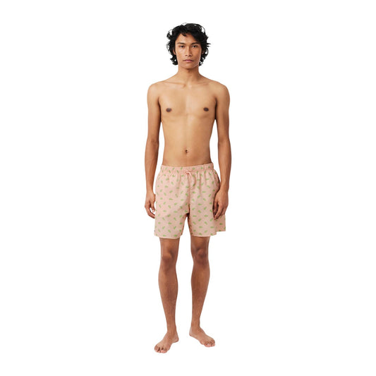 Costume Boxer Lacoste Rosa; Stampa Coccodrillo. 100% Poliestere riciclato, slip interno in mesh, vita regolabile. Tre tasche totali. Lunghezza 42 cm. Look estivo audace e sostenibile. Vista frontale figura intera 