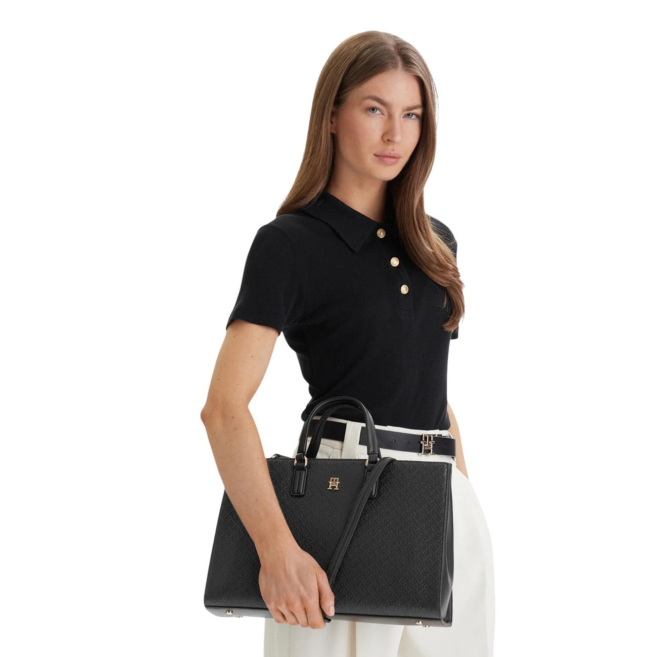 Tommy Hilfiger TH Daily Satchel; 100% poliuretano. Logo metallico dorato, piedini alla base, doppi manici. Borsa donna grande, strutturata e resistente per la stagione PE26. Colore nero vista frontale Indossata 
