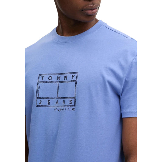T-shirt Tommy Jeans Azzurra; 100% Cotone Rigenerato. Regular fit, stampa grafica frontale, girocollo a costine. Stile casual sostenibile, ideale per la stagione calda e il tempo libero. Dettaglio 