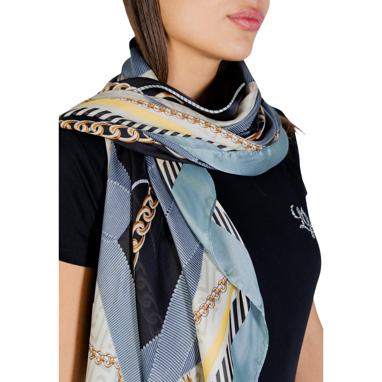 Foulard Liu Jo 120x120; Poliestere Riciclato. Stampa nastri e catene, leggero e versatile. Accessorio donna ecosostenibile ed elegante, perfetto per molteplici styling. Indossato da modella vista frontale dettaglio