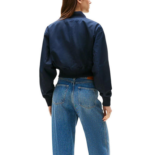Bomber Crop Tommy Hilfiger; Blu Navy. Tessuto idrorepellente, imbottitura termica, fit rilassato. Dettagli a coste, chiusura con zip e logo ricamato. Giacca corta funzionale e di tendenza. Vista posteriore 