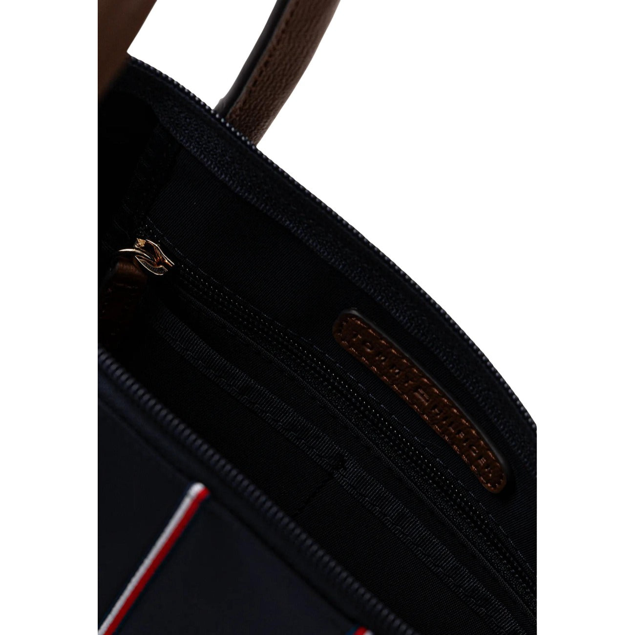 Borsa Tommy Hilfiger Nylon Tote; Chiusura con zip, tracolla rimovibile, nastro iconico TH. Capienza 7 litri, materiale leggero e resistente. Design moderno con manici a contrasto. Dettaglio cerniera