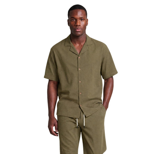 Camicia Bowling Verde Hydra Clothing; 100% Cotone. Maniche corte, vestibilità relaxed, chiusura con bottoni. Tessuto strutturato, leggero e fresco. Lo stile moderno per il tuo tempo libero estivo. Vista frontale 