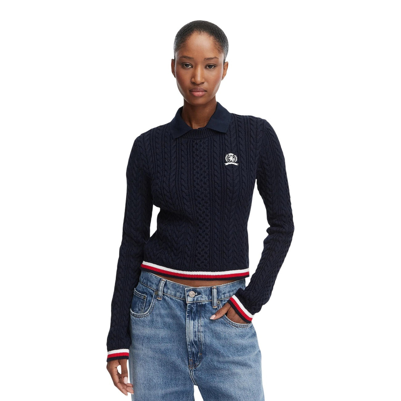 Maglione Polo Donna Blu Tommy Hilfiger Jeans; Maglia pesante cropped a trecce in cotone rigenerato. Colletto stile polo, maniche lunghe, dettagli tricolore sui bordi a coste e logo ricamato. Stile casual raffinato. Vista frontale 