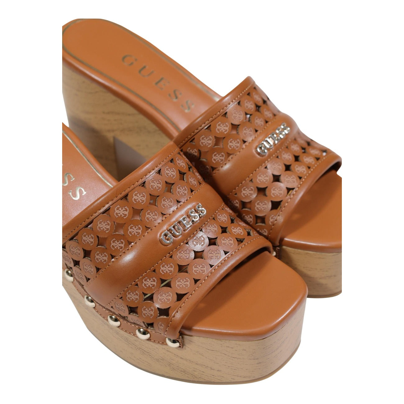 sandali zoccoli con tacco da donna Guess QUILL2. Realizzate al 100% in poliuretano, queste calzature presentano una tomaia lavorata con dettagli traforati e applicazioni gioiello. tacco largo e la suola piattaforma effetto legno. Dettaglio logo 