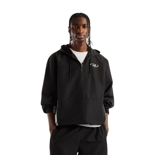 Giacca New Balance nera uomo MJ62Y8SJBK. Giambotto leggero da uomo nero di mezza stagione in poliestere con cappuccio regolabile, coulisse, zip integrale, polsi elasticizzati e logo al petto, giacca a vento casual sportiva.
