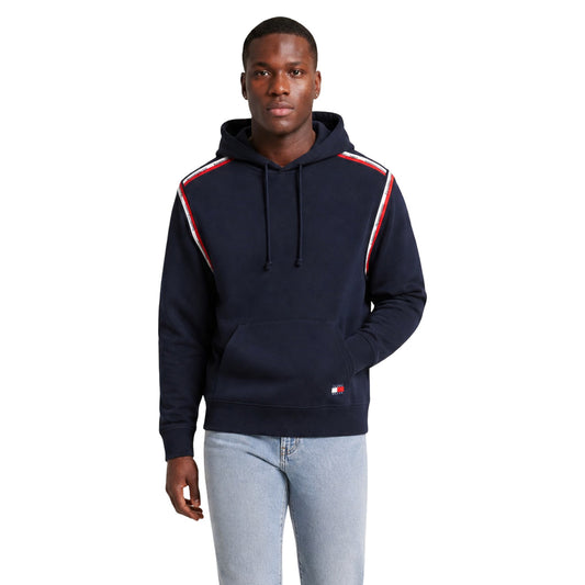 Felpa Cappuccio Uomo Tommy Hilfiger Jeans; Blu. 100% cotone rigenerato con tasca a marsupio, bande logo sulle spalle e scritte ricamate. Polsini a coste e vestibilità regolare, stile urban-casual. Frontale 