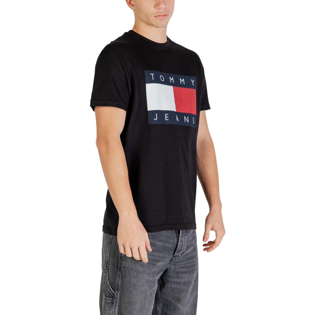 T-shirt Tommy Jeans Flag Badge; 100% Cotone. Regular fit, girocollo, logo ricamato. Maglia uomo in jersey di alta qualità, fresca e versatile per tutto l'anno. Colore nero vista laterale 