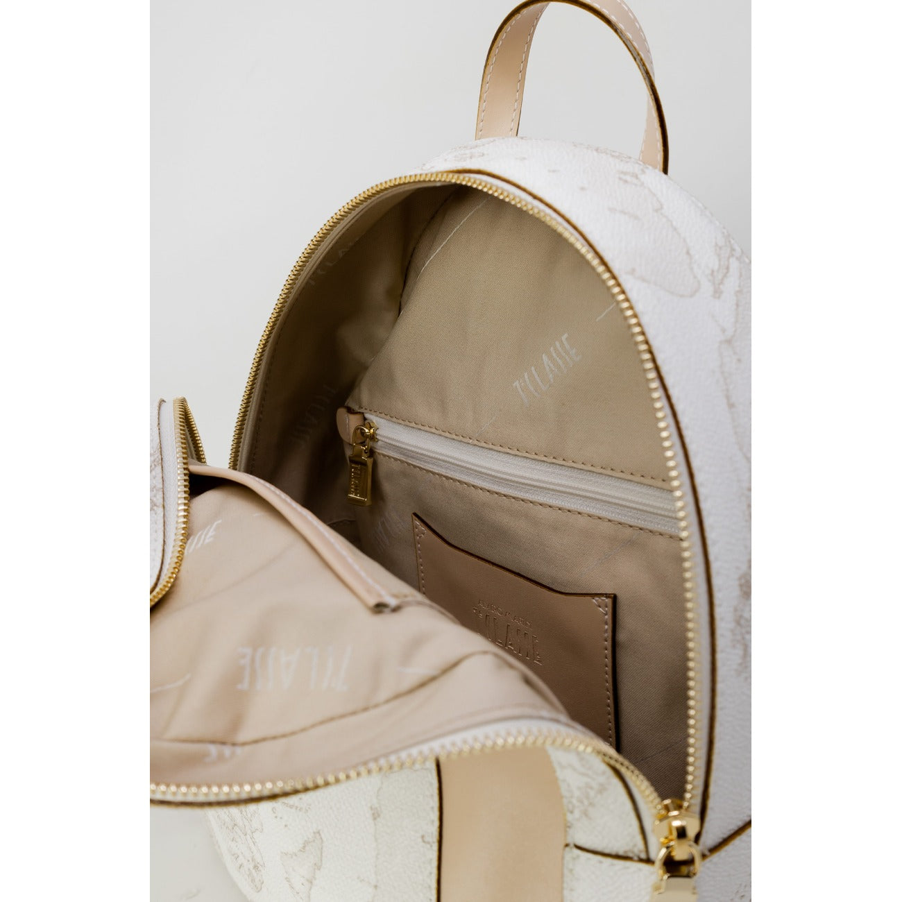 Zaino Medio Donna Alviero Martini Prima Classe; Bianco Geo White. Tessuto tecnico e 30% pregiata pelle stampata con dettagli metallici lucidi. Chiusura con zip, tasca frontale e spallacci regolabili. Misure slanciate e capienti (25x29 cm). Vista apertura 