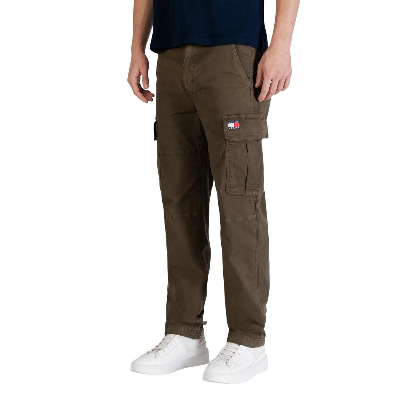 Pantaloni Cargo Tapered Tommy Hilfiger; Verde. Cotone rigenerato, vestibilità comoda affusolata, tasche laterali con patta. Stile utility iconico e sostenibile, ideale per la stagione fredda. Frontale laterale 