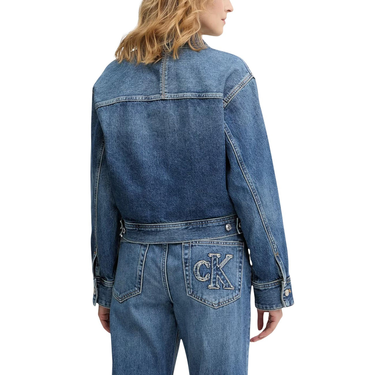 Giacca Cropped Calvin Klein; Blu Denim. 100% Cotone. Taglio corto, tasche frontali, bottoni in metallo, logo "CK" ricamato. Stile casual/urban per tutte le stagioni. Posteriore 