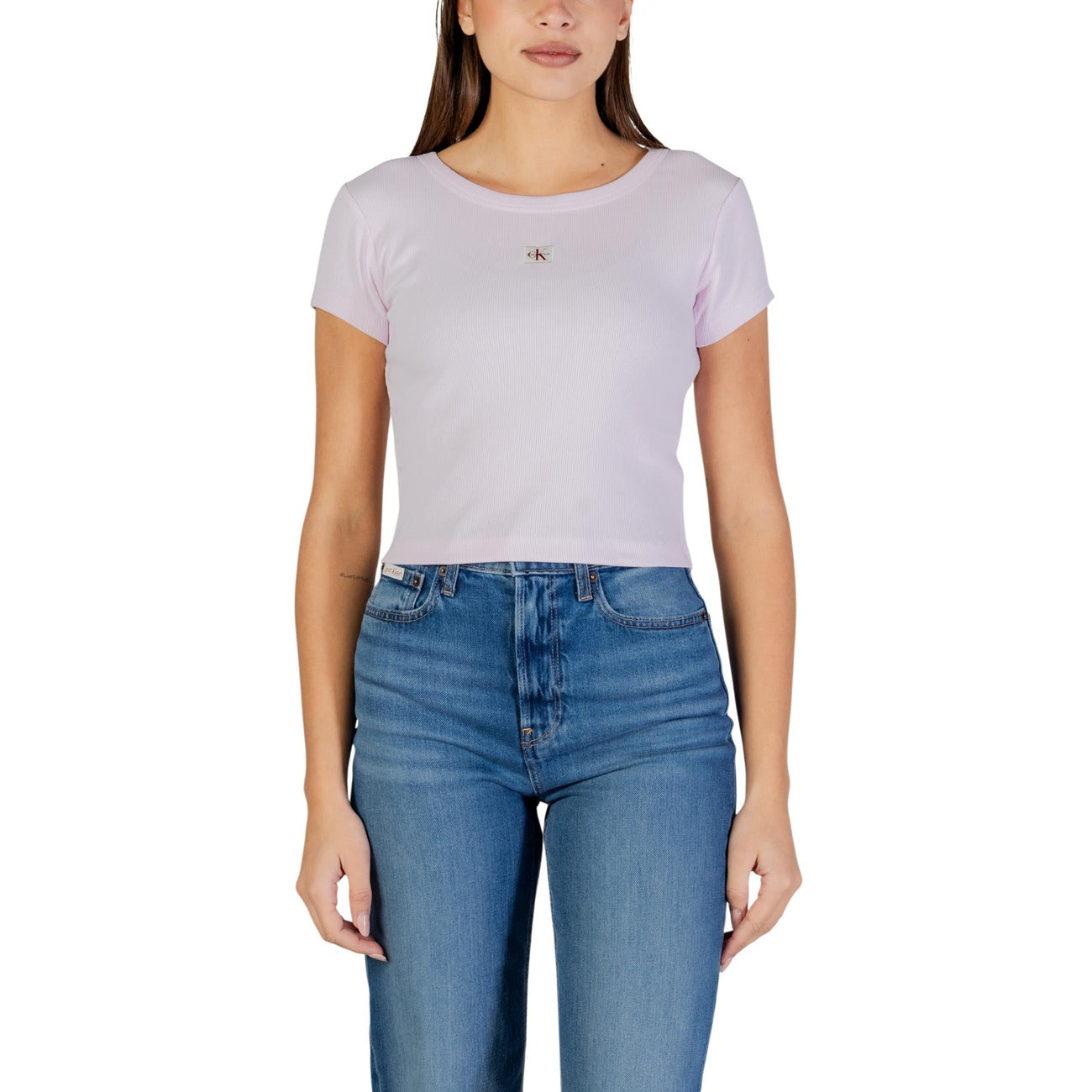 T-shirt CK Jeans Woven Label; 95% Cotone, 5% Elastane. Lavorazione a costine, manica corta, vestibilità aderente. Maglia donna versatile, morbida e di alta qualità. Colore rosa vista frontale Indossata da modella 