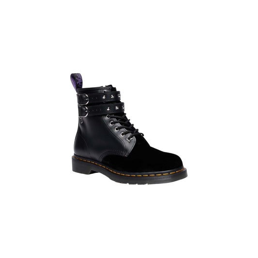 Anfibi Dr Martens Wednesday Addams 1460 neri. Stivaletti in velluto nero e pelle con cinturini decorativi, borchie argentate, ciondolo rosone, scritte ricamate viola, suola alta e impunture gialle.