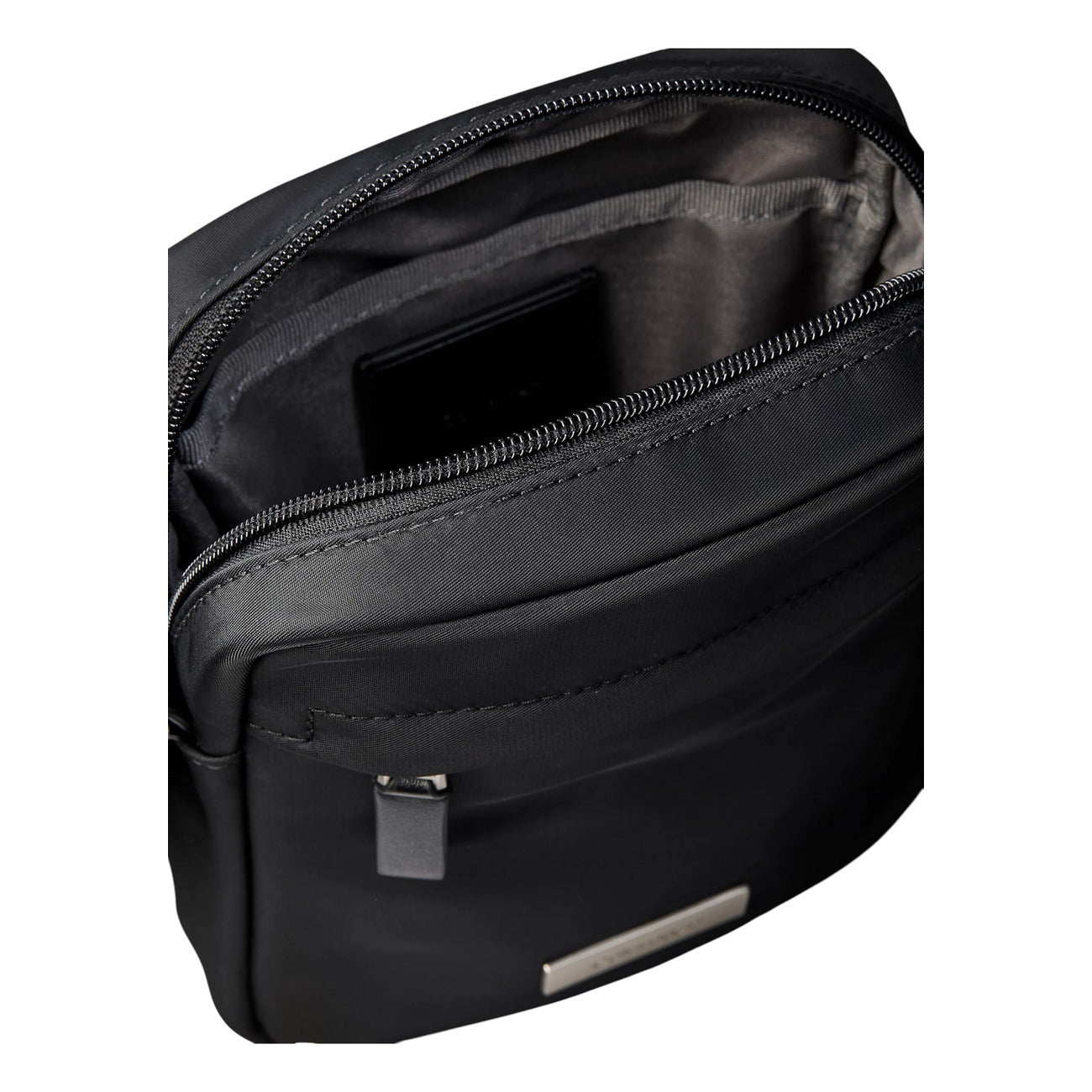 Borsa Tracolla Uomo Calvin Klein Clean Reporter; Nero. 100% Nylon riciclato ecosostenibile, doppia chiusura con zip, tracolla regolabile in tessuto e divisori interni. Dimensioni compatte (16x20 cm), stile minimalista e leggero. Vista aperta 
