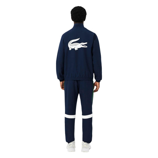 Lacoste Tennis Tracksuit Navy/White; 100% poliestere, resistente all'acqua, fondo gamba con zip. La tuta da tennis professionale classica e traspirante. Vista frontale 