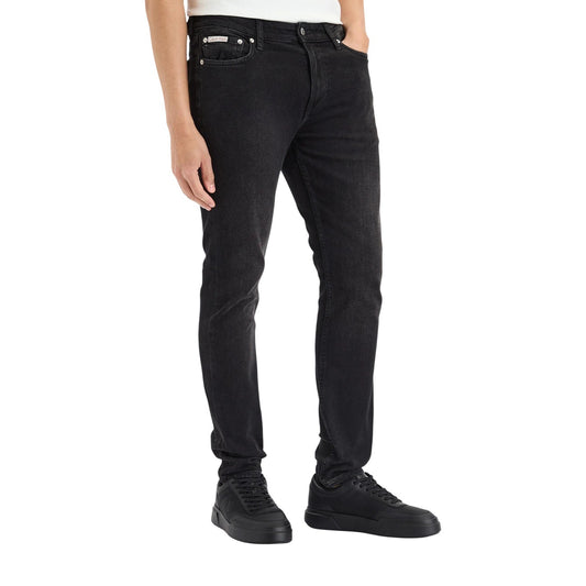 Jeans Slim Neri Calvin Klein; Cotone Stretch. Taglio 5 tasche, vita regular, chiusura con zip. Patch logo in pelle, vestibilità aderente e confortevole. Il classico denim nero rivisitato. Vista frontale 