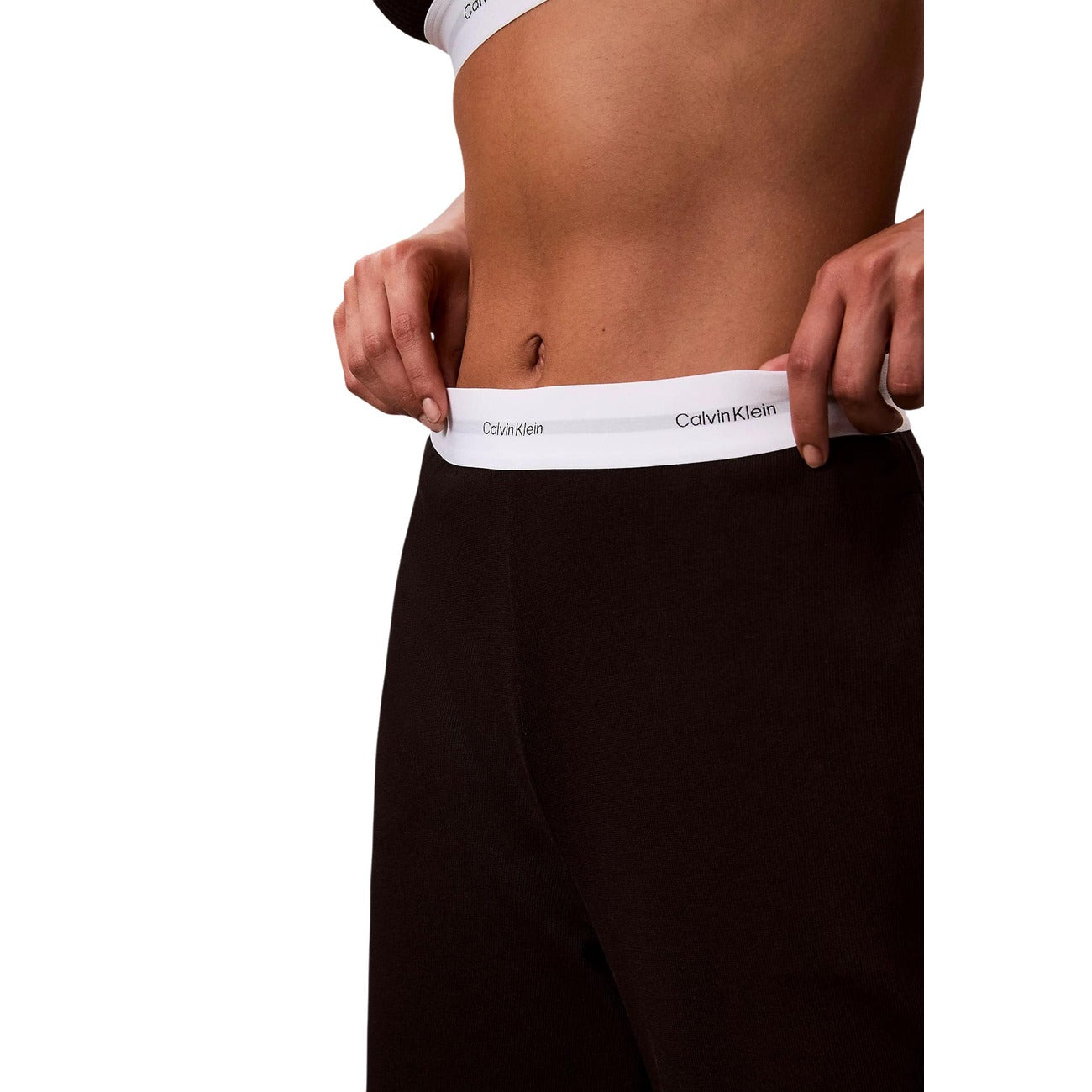 Pantaloni pigiama Calvin Klein donna neri modello LOGO JERSEY PANT. Pantalone lungo da notte e loungewear in maglia di cotone a coste tinta unita con tasche laterali e fondo con risvolto, dotato di fascia elastica logata in vita, stile casual sportivo e minimale.