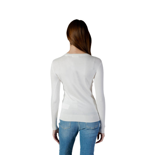 Maglia Guess Stephanie; Bianco. 82% Viscosa, 16% Poliammide, 2% Elastam. Scollo a V, logo gioiello, maniche lunghe. Tessuto fluido e aderente, stile chic quotidiano. Posteriore 