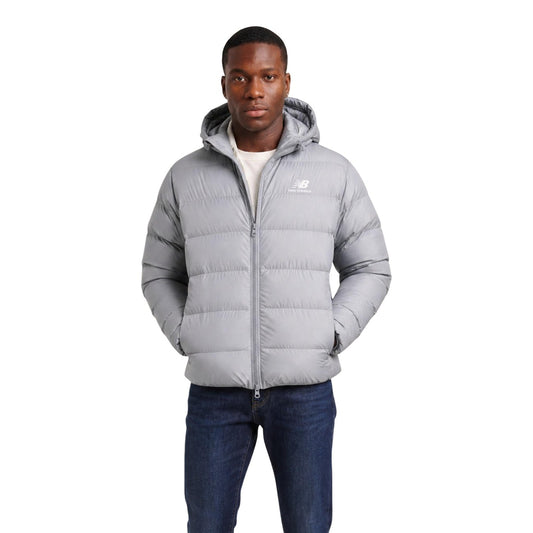 Piumino uomo New Balance grigio MJ62G17OYST. Giacca invernale pesante da uomo grigia con trapuntatura orizzontale, cappuccio, zip integrale, tasche con cerniera e logo ricamato, giubbotto casual sportivo da mezza stagione e freddo.