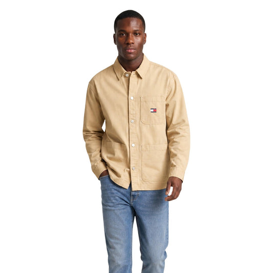 Camicia Beige Tommy Jeans; Utility Style. 100% Cotone Rigenerato. Doppia tasca frontale, logo ricamato, vestibilità regolare. Robusta, versatile e attenta all'ambiente. Vista frontale 